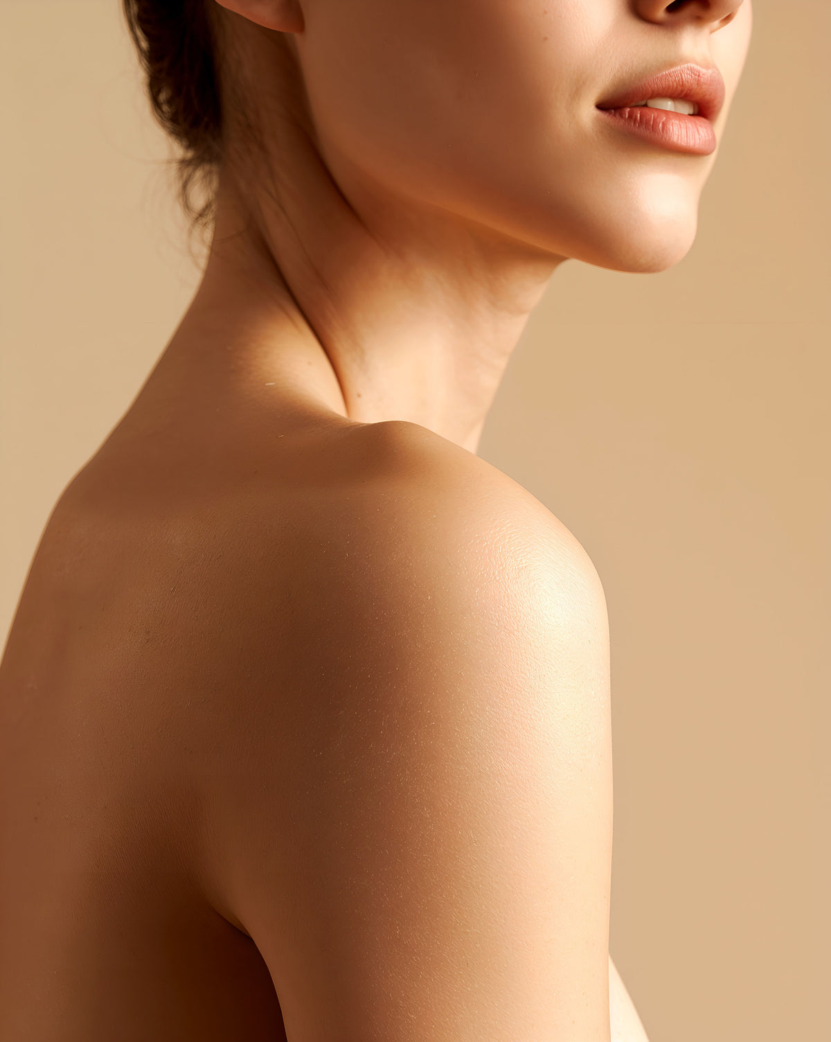 Side profile of a woman's bare shoulder and jaw with smooth, healthy skin