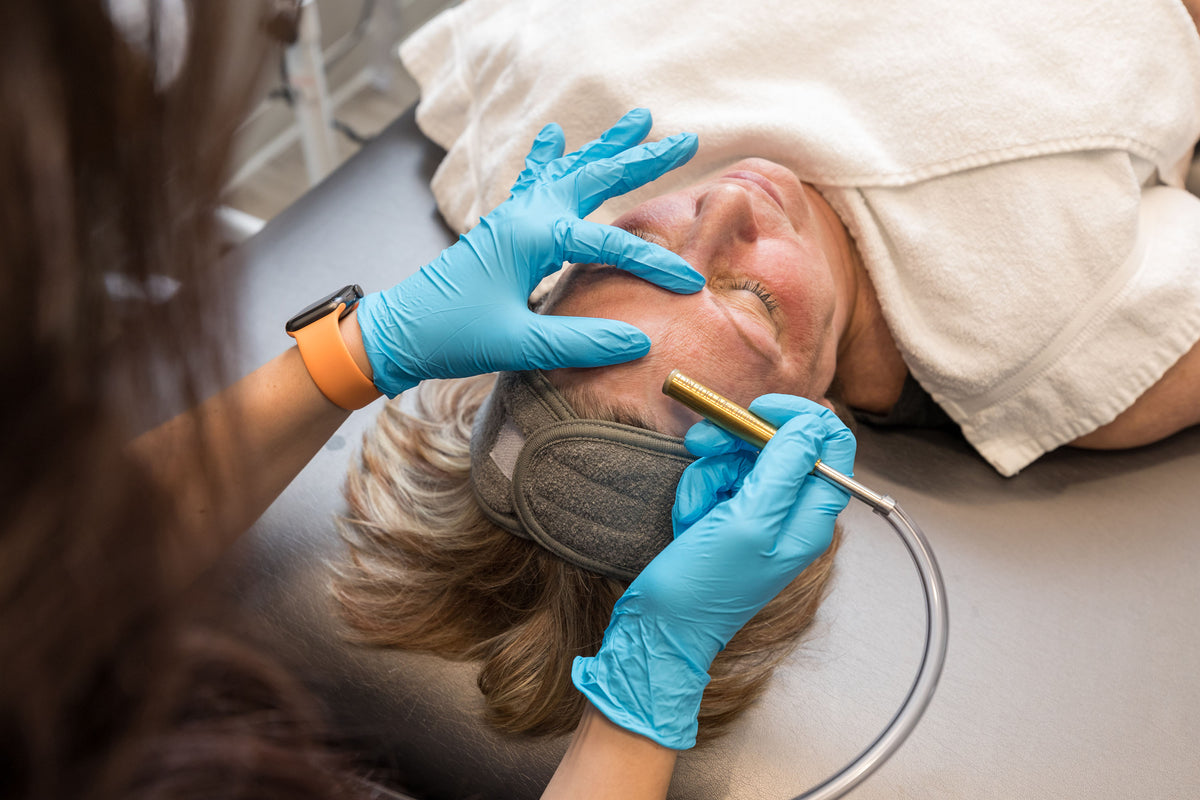 Gloved clinician using a diamond-tipped microdermabrasion handpiece on a patient's face at Element Dermatology