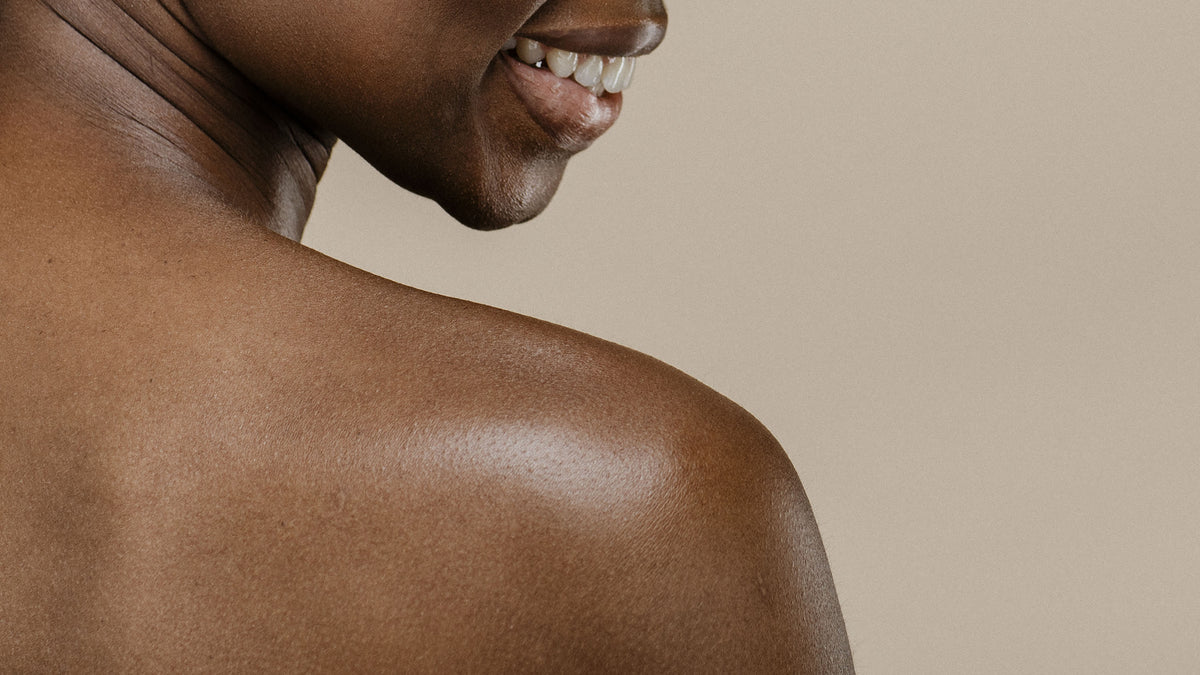 Close-up of a woman's neck and bare shoulder with smooth, even skin tone