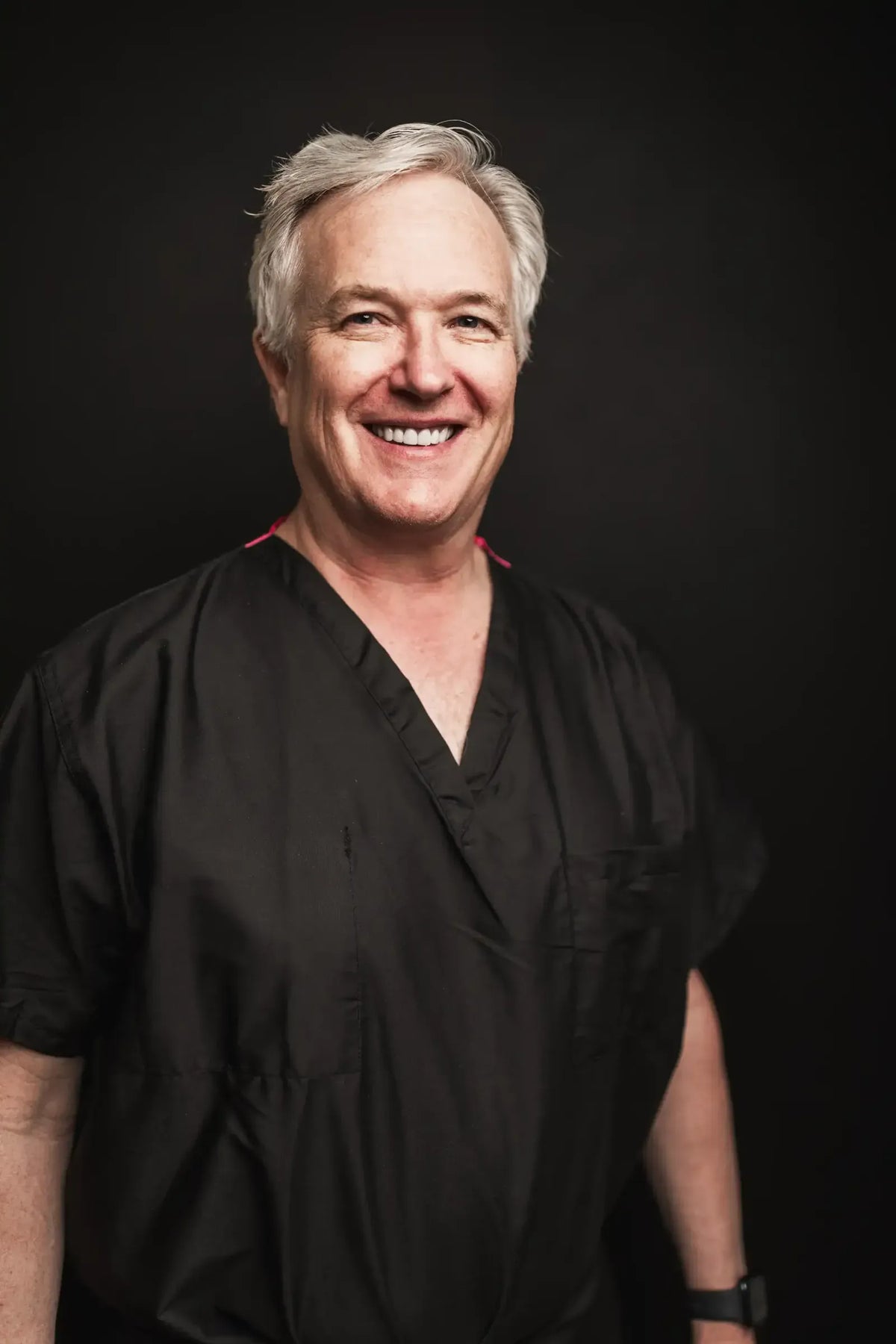 Dr. Barry LaBine, dermatologist at Element Dermatology, smiling in black scrubs